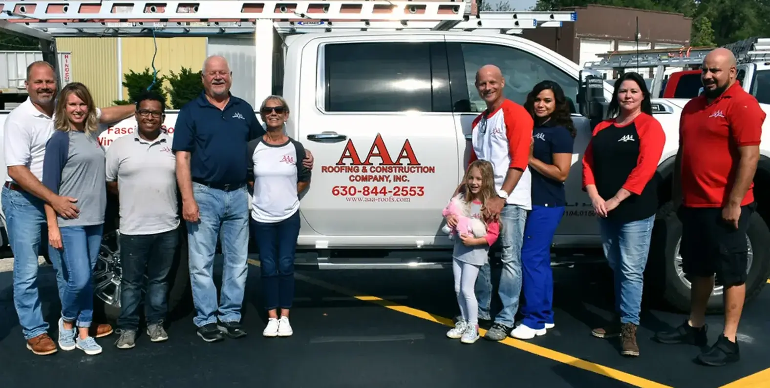 The AAA Roofing Company team standing in front of a company truck